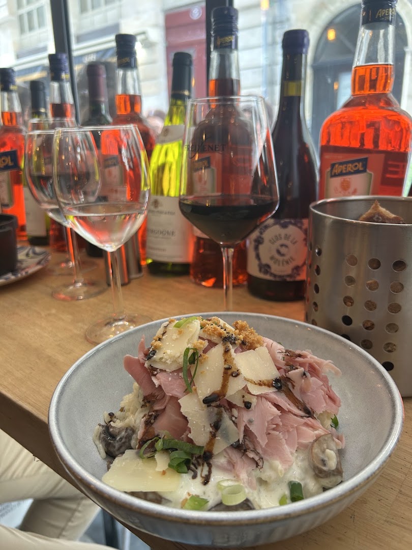 Une salade composée servie devant une sélection de vins