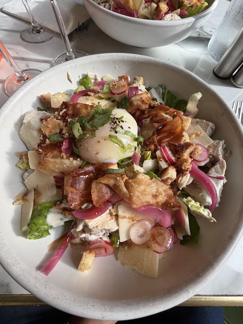 Une burrata entourée de légumes, salade et oignons